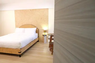 a bedroom with a white bed and a table at Area 69 (Don Muang Airport) in Bangkok