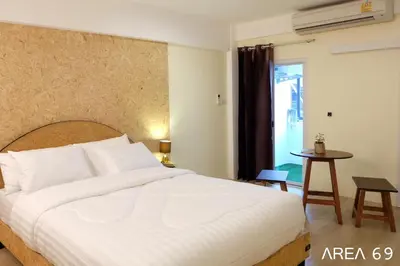 a bedroom with a large white bed and a table at Area 69 (Don Muang Airport) in Bangkok