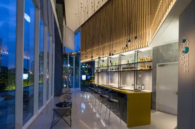 a bar in a building with a lot of windows at Modena by Fraser Bangkok in Bangkok