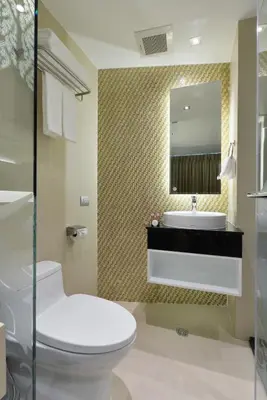 a bathroom with a toilet and a sink and a mirror at Aspira G Sukhumvit 33 in Bangkok