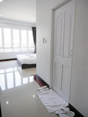 a bedroom with a door and two beds and a mirror at Room58 in Bangkok