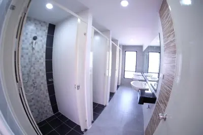 a bathroom with a mirror and two sinks and a shower at Hide Bangkok Hostel in Bangkok