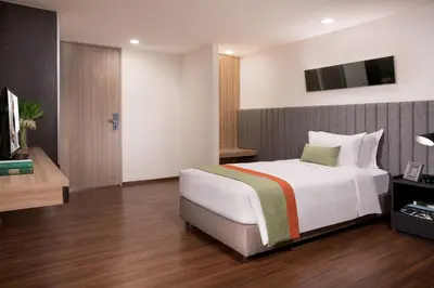 a bedroom with a bed and a tv on a wall at Somerset Ekamai Bangkok in Bangkok