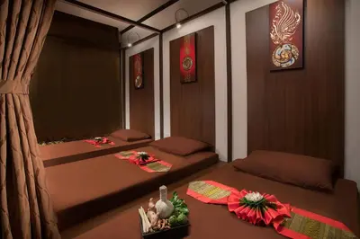 a room with two beds and a table with flowers at Somerset Ekamai Bangkok in Bangkok