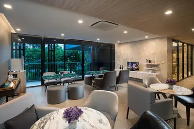 a restaurant with tables and chairs and windows at Somerset Ekamai Bangkok in Bangkok
