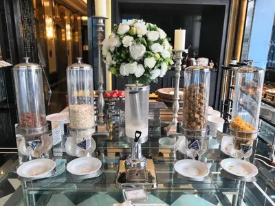 a glass table topped with a vase filled with food at Grande Centre Point Sukhumvit 55 Thong Lo in Bangkok