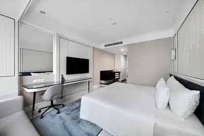a bedroom with a bed and a desk and a television at Grande Centre Point Sukhumvit 55 Thong Lo in Bangkok
