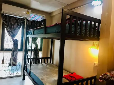 two bunk beds in a room with a window at Pailin Guest House in Bangkok