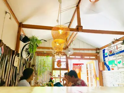 a group of people sitting at a bar at Pailin Guest House in Bangkok