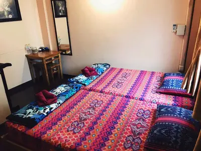 a bedroom with a bed with a colorful comforter at Pailin Guest House in Bangkok