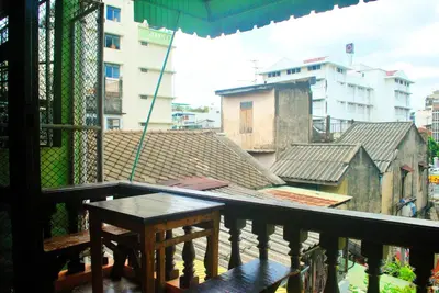 a balcony with a table and a view of buildings at Pailin Guest House in Bangkok