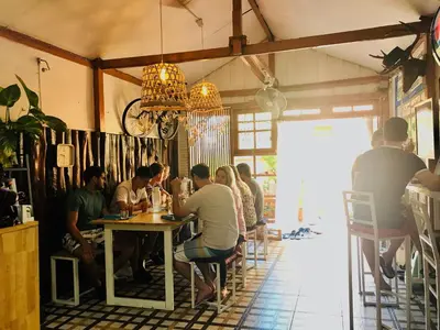a group of people sitting at a table in a restaurant at Pailin Guest House in Bangkok