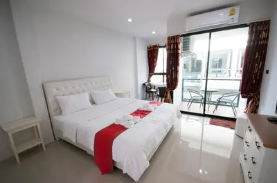 a bedroom with a white bed with a red blanket at The Pool Resort in Bangkok
