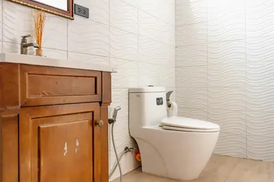 a bathroom with a white toilet and a sink at The Pool Resort in Bangkok