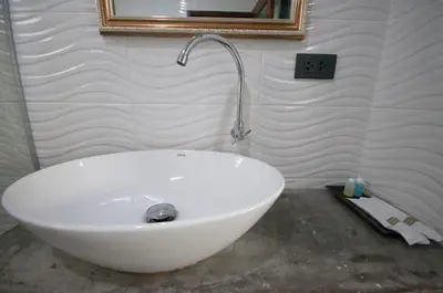 a white sink in a bathroom with a mirror at The Pool Resort in Bangkok