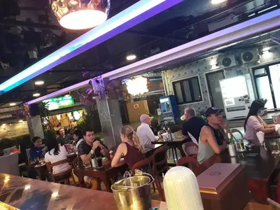 a group of people sitting at tables in a restaurant at Maderla in Bangkok