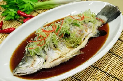 a plate of food with a fish in a bowl of soup at Maderla in Bangkok