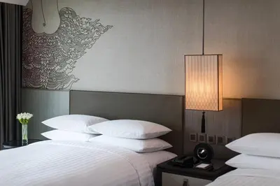 a hotel room with two beds with white pillows at Bangkok Marriott Marquis Queens Park in Bangkok