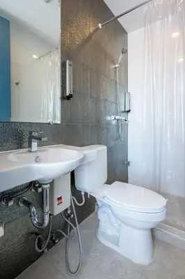 a bathroom with a white toilet and a sink at 128 room and massage in Bangkok