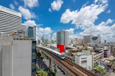 a train on tracks in a city with buildings at 128 room and massage in Bangkok
