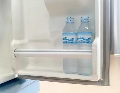 two bottles of water are inside of an open refrigerator at 128 room and massage in Bangkok