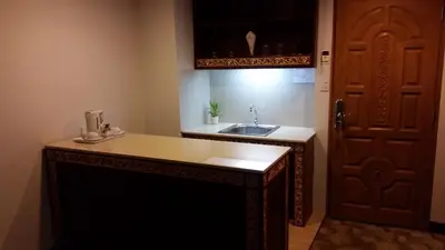 a kitchen with a sink next to a door at Ariston Hotel Bangkok in Bangkok