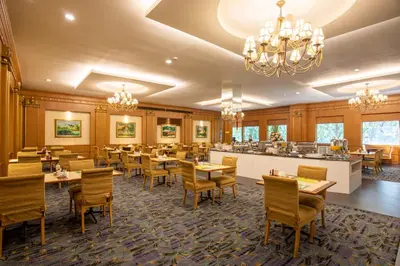 a restaurant with tables and chairs and a bar at Ariston Hotel Bangkok in Bangkok