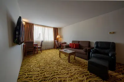 a living room with a couch and a table at Ariston Hotel Bangkok in Bangkok