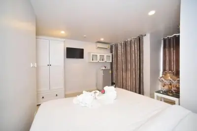 a bedroom with a large white bed with towels on it at Parvena Hotel Sathorn in Bangkok