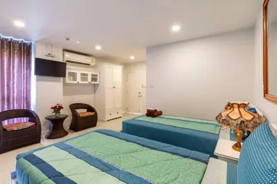 a bedroom with two beds in a room at Parvena Hotel Sathorn in Bangkok