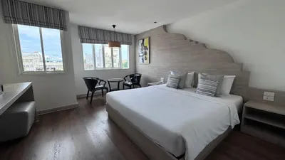 a bedroom with a large bed and a staircase at Methavalai Residence Hotel in Bangkok