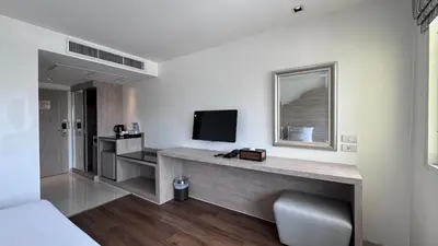 a hotel room with a desk and a television at Methavalai Residence Hotel in Bangkok