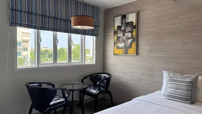 a bedroom with a bed and a table and chairs at Methavalai Residence Hotel in Bangkok