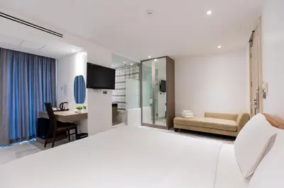 a hotel room with a bed and a desk at Sukhothai Residence Ruam Ruedi in Bangkok