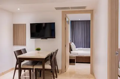 a room with a table and chairs and a bedroom at Sukhothai Residence Ruam Ruedi in Bangkok