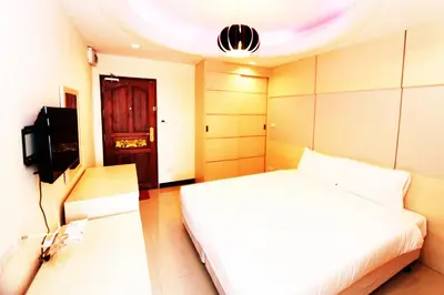 a bedroom with a white bed and a tv at T3 Residence in Bangkok