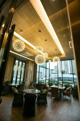 a lobby with a table and chairs and windows at Arte Hotel - SHA Extra Plus in Bangkok