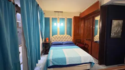 a bedroom with a bed with blue and white sheets at Café de Baan Raow in Bangkok