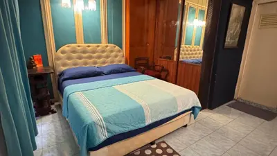 a bedroom with a bed and a mirror in it at Café de Baan Raow in Bangkok