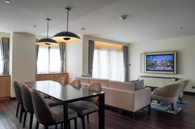a living room with a couch and a table and chairs at Marriott Executive Apartments Bangkok, Sukhumvit 50 in Bangkok