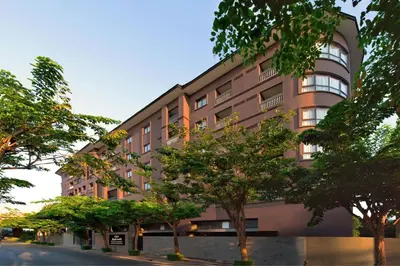 a building with trees in front of a street at Marriott Executive Apartments Bangkok, Sukhumvit 50 in Bangkok