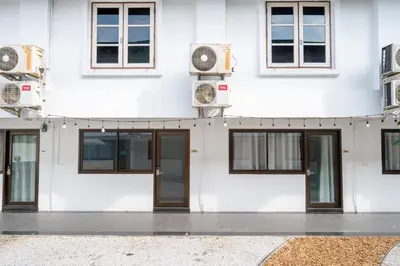 a white building with doors and windows at The President Hotel at Chokchai 4 in Bangkok