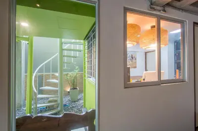 a room with green walls and a staircase with a mirror at ST88 Residence in Nonthaburi