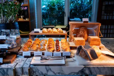 a display of bread and pastries on a table at 137 Pillars Residences Bangkok in Bangkok