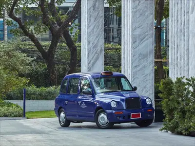 a small blue car parked in front of a building at 137 Pillars Residences Bangkok in Bangkok