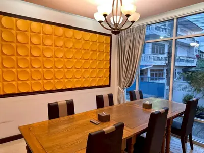 a dining room with a wooden table and a large window at ลีลาวดี รามอินทรา - Leelawadee Resotel Raminthra 23 in Bangkok