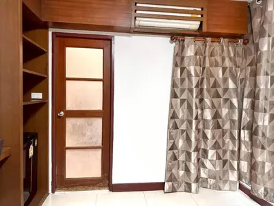 a room with a door and a window with a curtain at ลีลาวดี รามอินทรา - Leelawadee Resotel Raminthra 23 in Bangkok