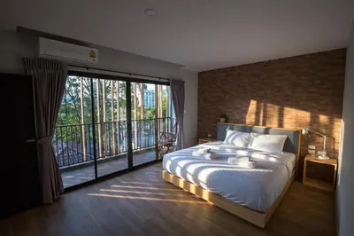 a bedroom with a large bed and a balcony at Nest by Sangob in Bangkok
