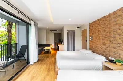 a bedroom with two beds and a brick wall at Nest by Sangob in Bangkok