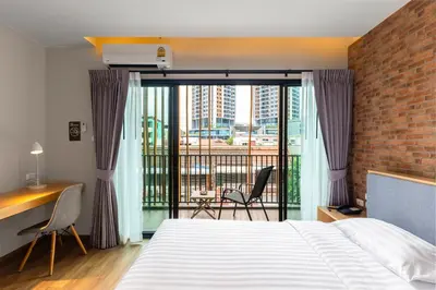 a bedroom with a bed and a balcony at Nest by Sangob in Bangkok
